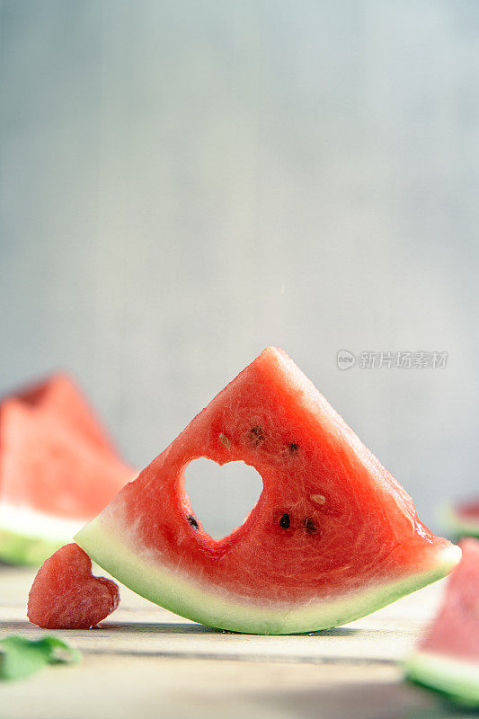 A cut piece of watermelon with a heart-shaped hole. Summer, joy, happiness, delicious food